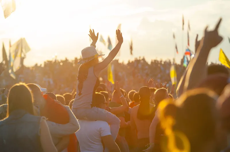 A dancing crowd at a festival, with sun shining